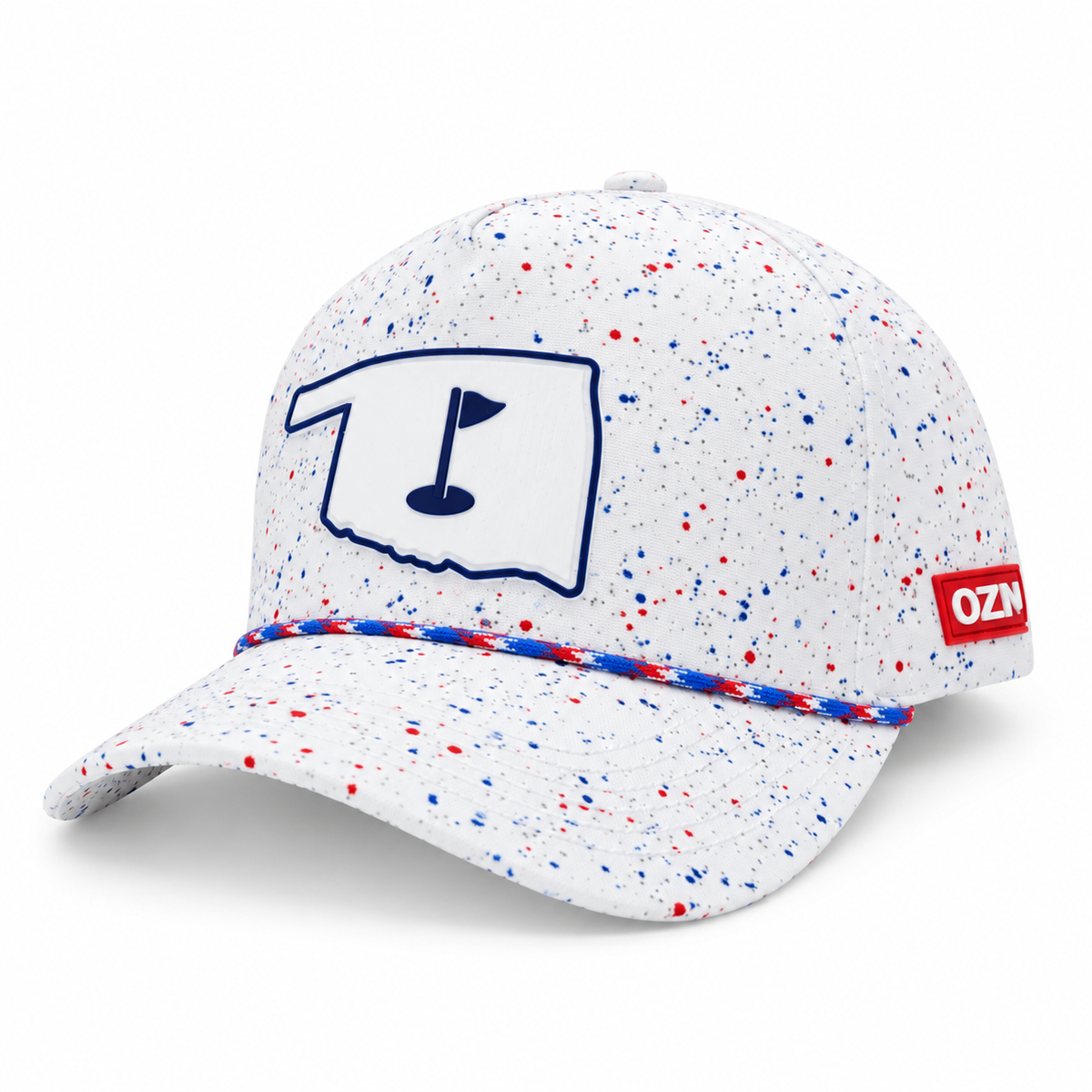 A white baseball cap with red and blue speckled paint splatter, featuring a navy blue outline of Oklahoma on the front with a golf flag icon, and a red side patch with 'OZN' in white.